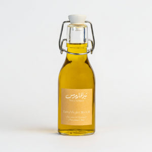 Bottle of olive oil with a gold label on a white background