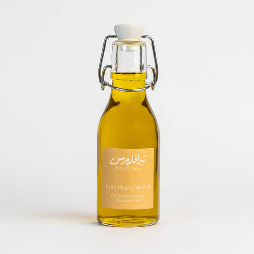 Bottle of olive oil with a gold label on a white background